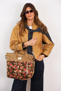 Model holding the DE LA MUR Pepi floral jacquard large handbag in brown & red, lifestyle shot