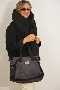 Model carrying the black DE LA MUR Cene faux suede large shoulder bag on the shoulder