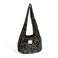 DE LA MUR Teide floral jacquard oval shoulder bag in black and beige, front view