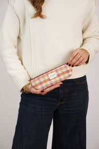 Model holding the DE LA MUR gingham jacquard pencil case in terracotta and orange