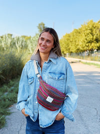 Model wearing the DE LA MUR Aura striped jacquard fanny pack crossbody outdoors