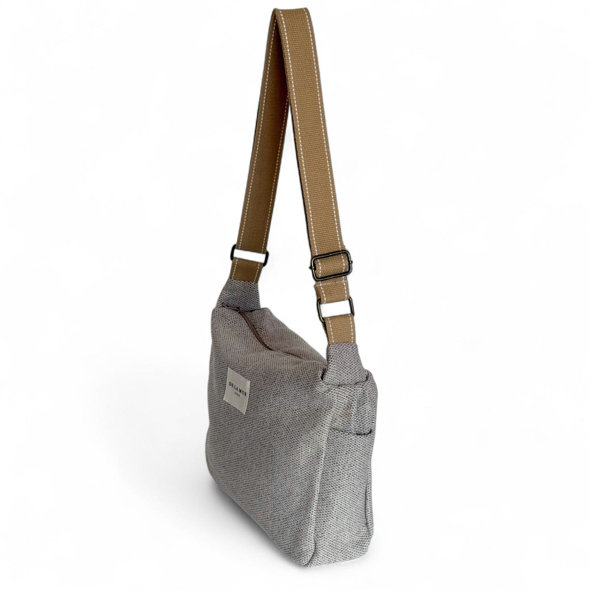 DE LA MUR Sydney handbag side view showing tan crossbody strap and slip pocket