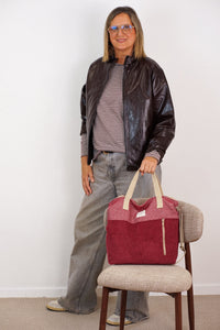 Model presenting the burgundy corduroy DE LA MUR Arde large handbag, lifestyle shot