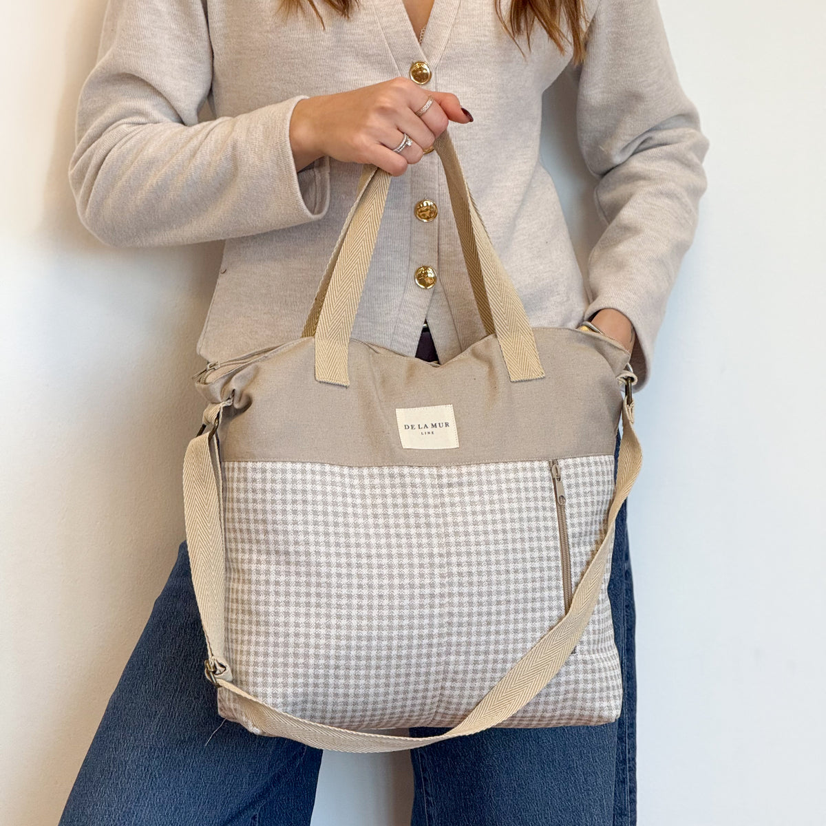 Model holding the DE LA MUR Vison vichy check handbag, three-quarter view