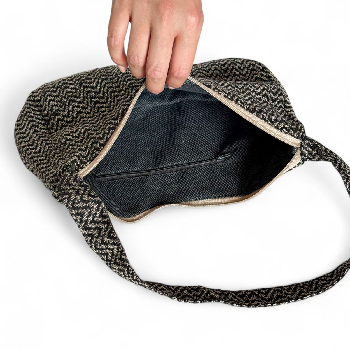 Open DE LA MUR Dana shoulder bag showing dark lined interior with zip pocket