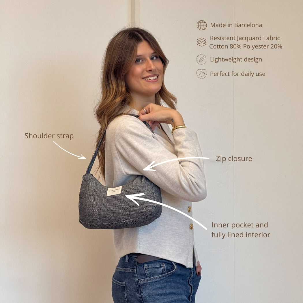 Model wearing the DE LA MUR Sinay black shoulder bag, with feature callouts