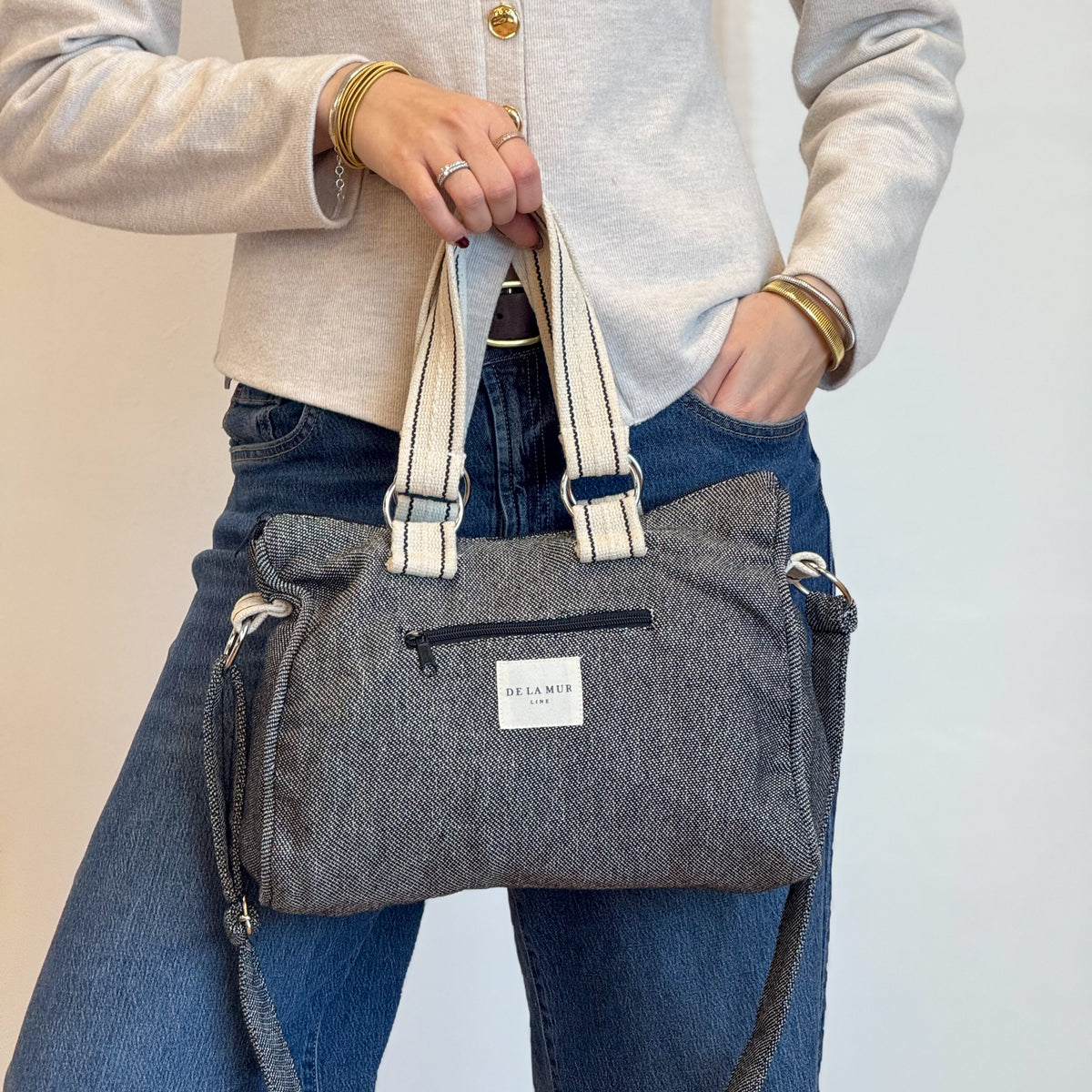 Model holding the DE LA MUR Sinay gray herringbone city handbag