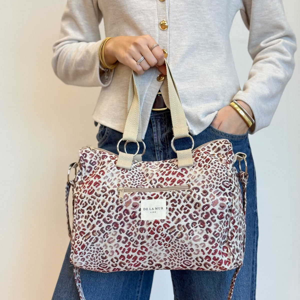 Model holding the DE LA MUR Talco leopard print city handbag
