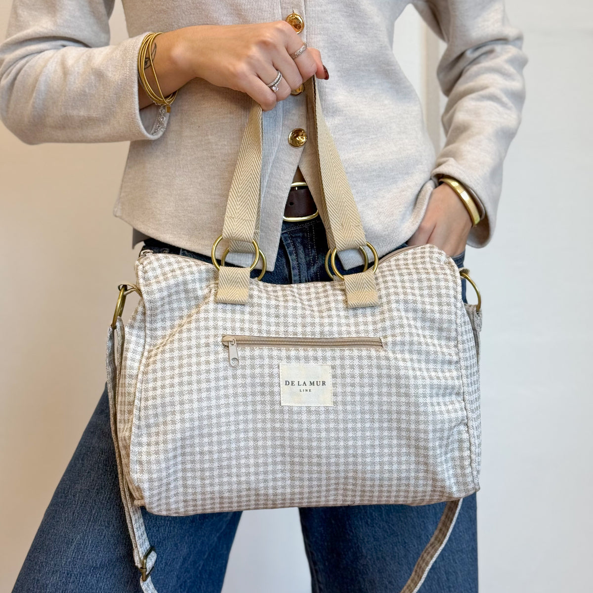 Model holding the DE LA MUR Vison gingham off-white city handbag