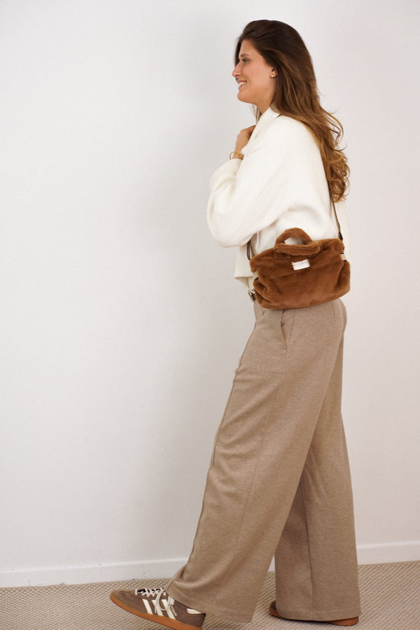 DE LA MUR camel brown faux fur small handbag worn crossbody, side view on a walking model
