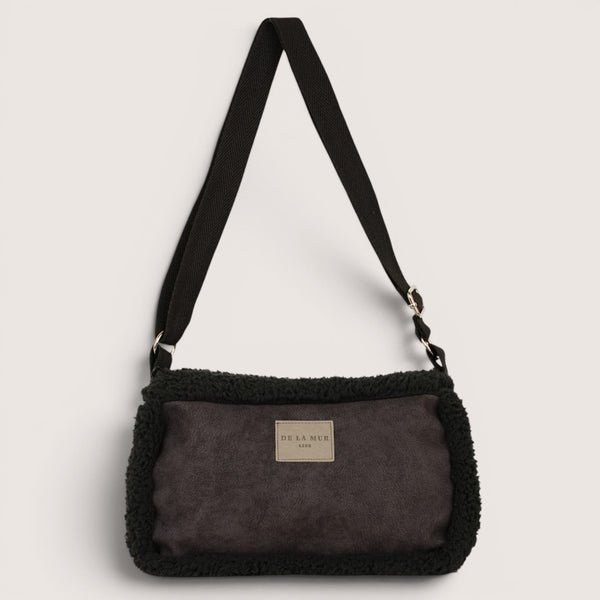DE LA MUR Cene faux suede small shoulder bag in black, front view with adjustable strap