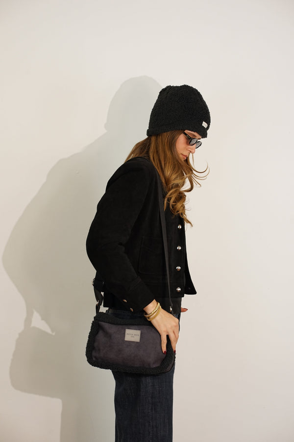 Side profile of a model wearing the DE LA MUR Cene small crossbody bag