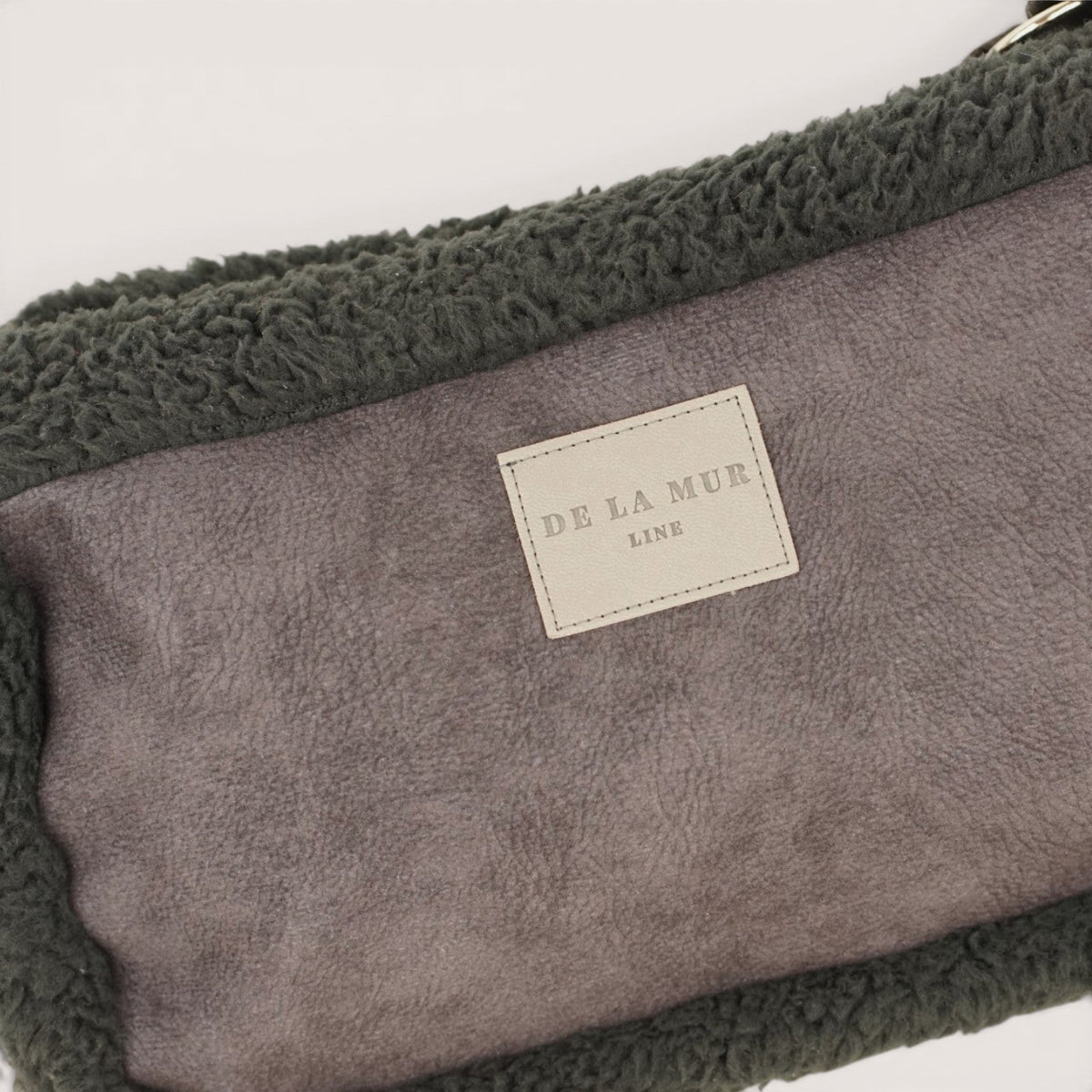 Close-up of the DE LA MUR Line label on the black Cene small shoulder bag