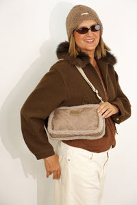 Model wearing the taupe DE LA MUR Noce faux suede small shoulder bag crossbody