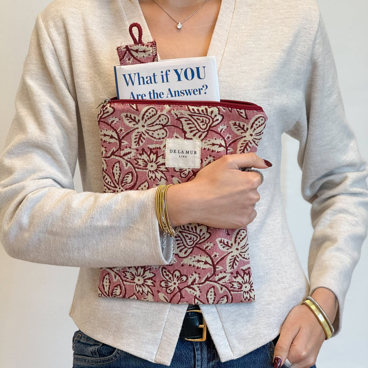 Model holding the DE LA MUR Came pink floral book cover with book and bookmark