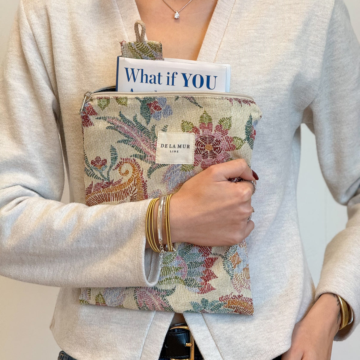 Model holding the DE LA MUR Color floral jacquard book cover with book and bookmark