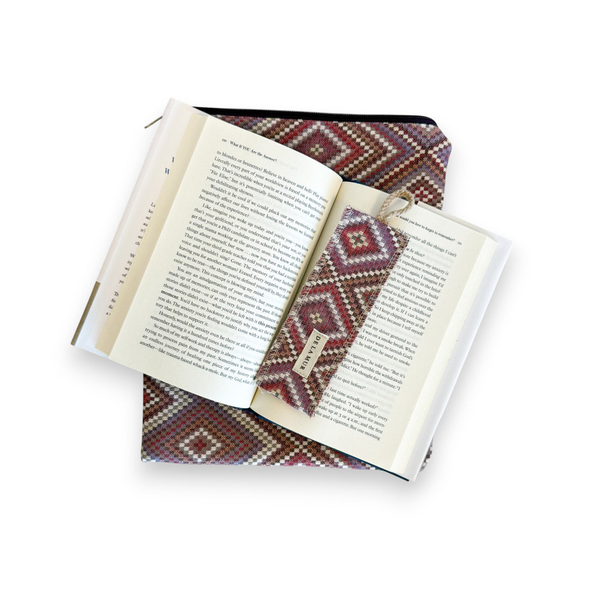Open book on the DE LA MUR Nana geometric cover with the matching woven bookmark in place
