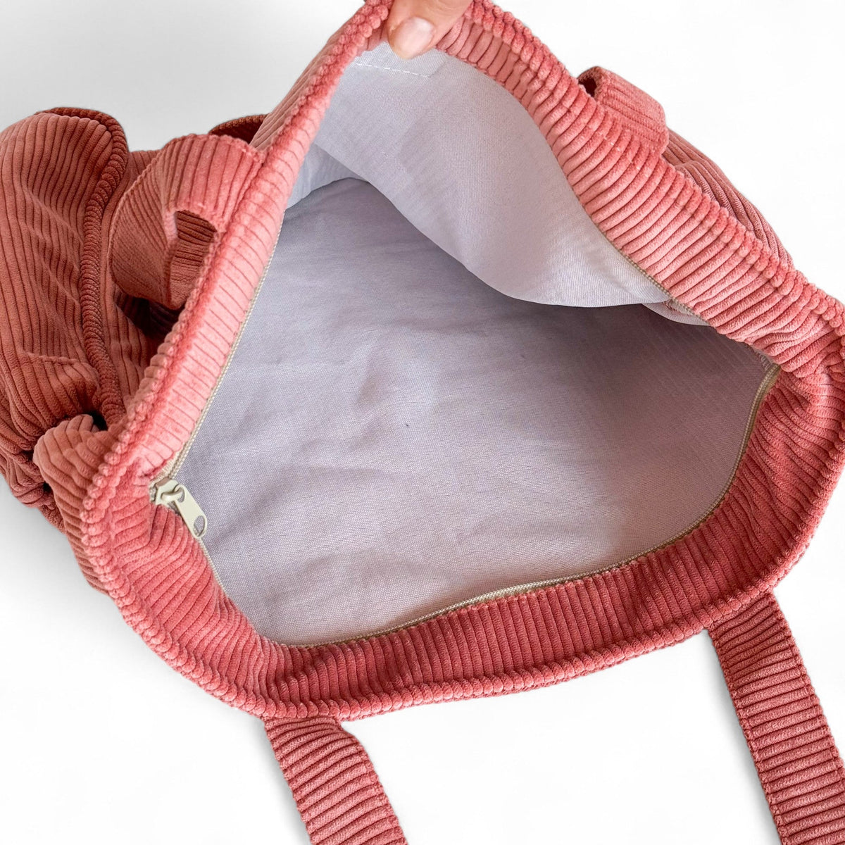 Open DE LA MUR coral corduroy tote bag showing the white lined interior