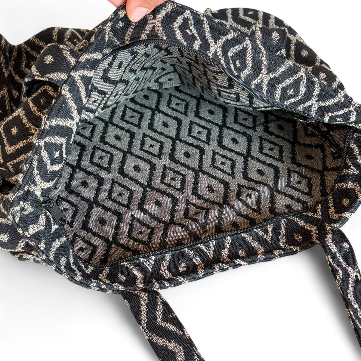 Open DE LA MUR Onix tote bag showing the patterned lined interior and zipper