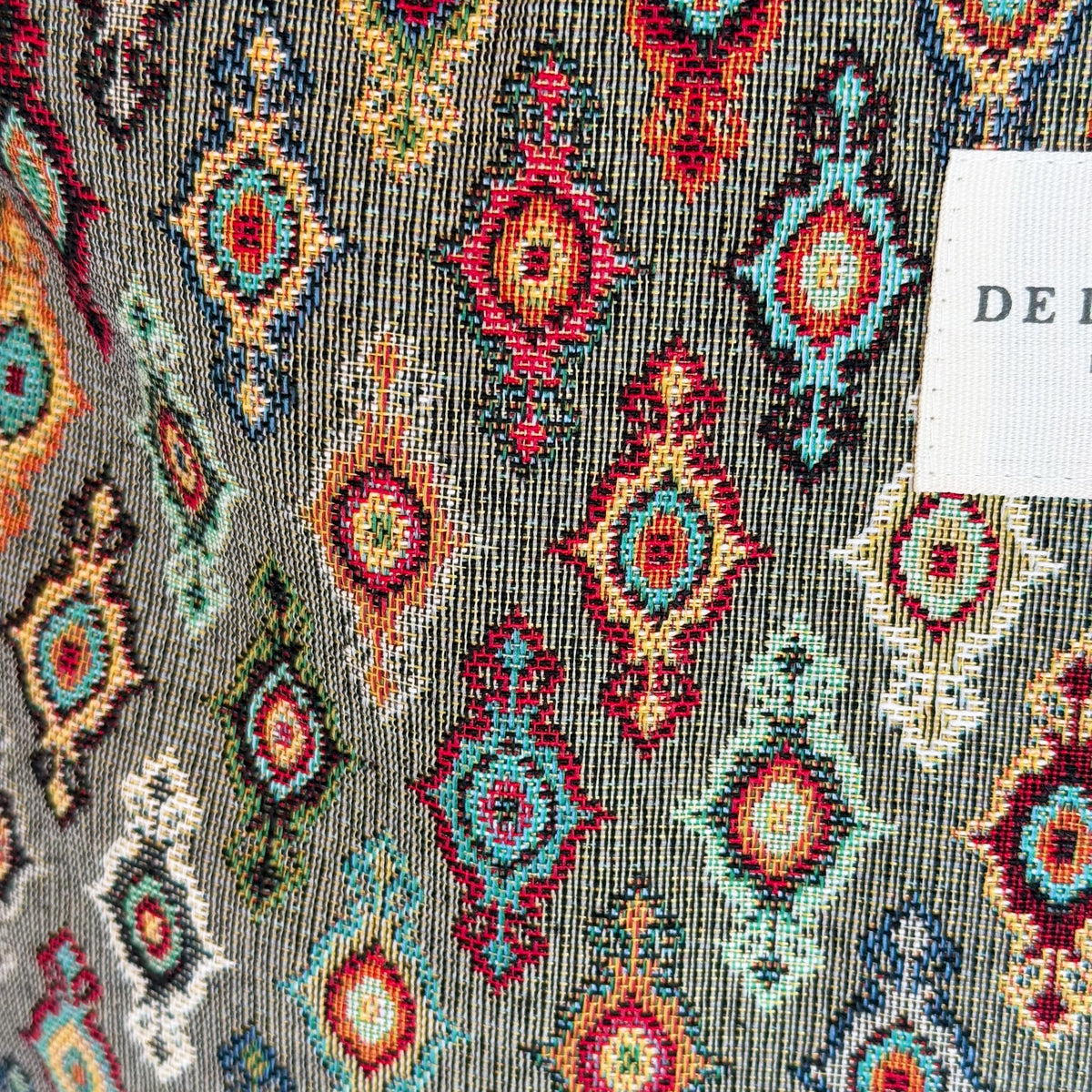 Close-up of the multicolor geometric jacquard weave and DE LA MUR label