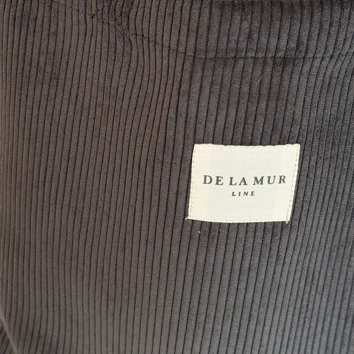 Close-up of the gray corduroy texture and DE LA MUR Line label