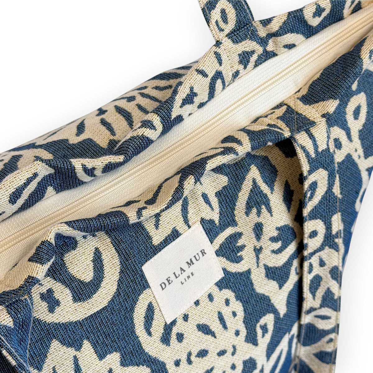 Model carrying the DE LA MUR Akay floral jacquard tote bag on her shoulder, front view
