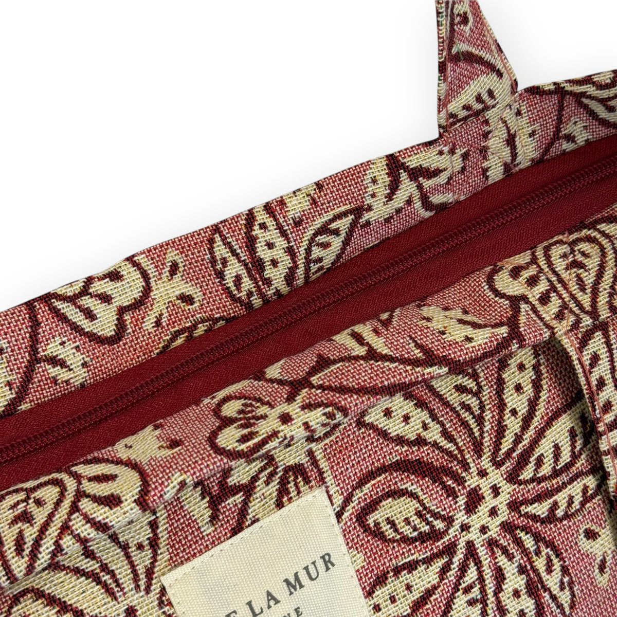 Close-up of the DE LA MUR Came tote zip closure and Line label