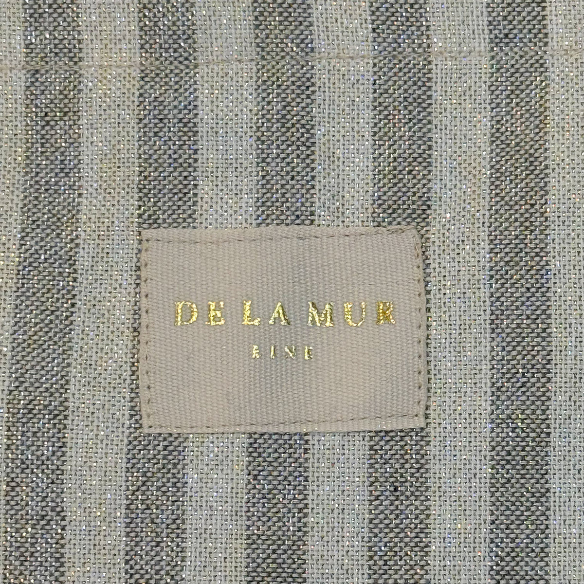 Close-up of the DE LA MUR Line gold-flecked gray striped tote fabric