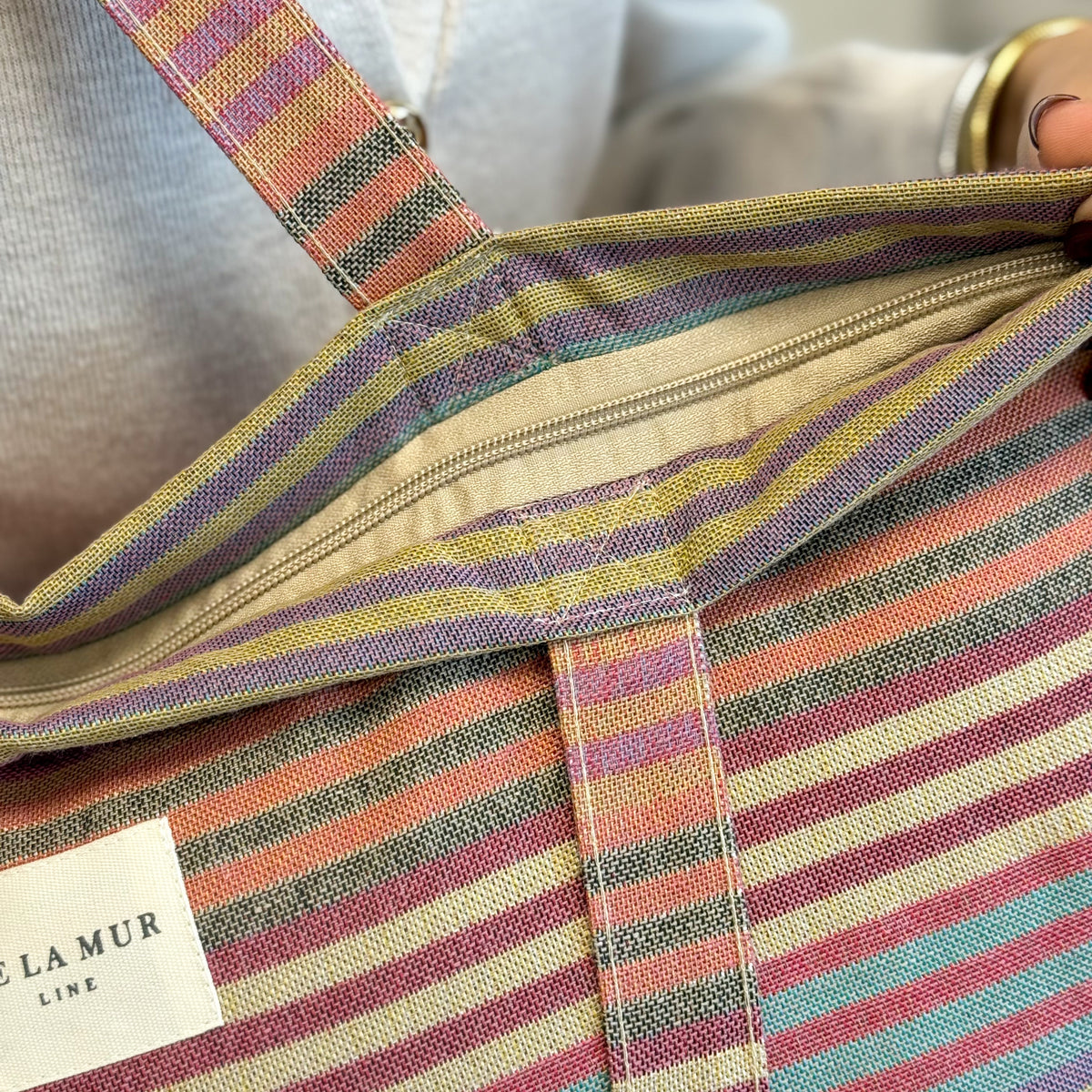 Open DE LA MUR multicolor striped tote showing the lined interior