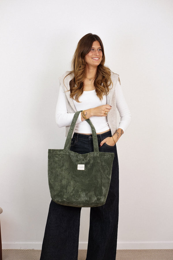 Model holding DE LA MUR Musgo olive green corduroy tote bag, lifestyle shot