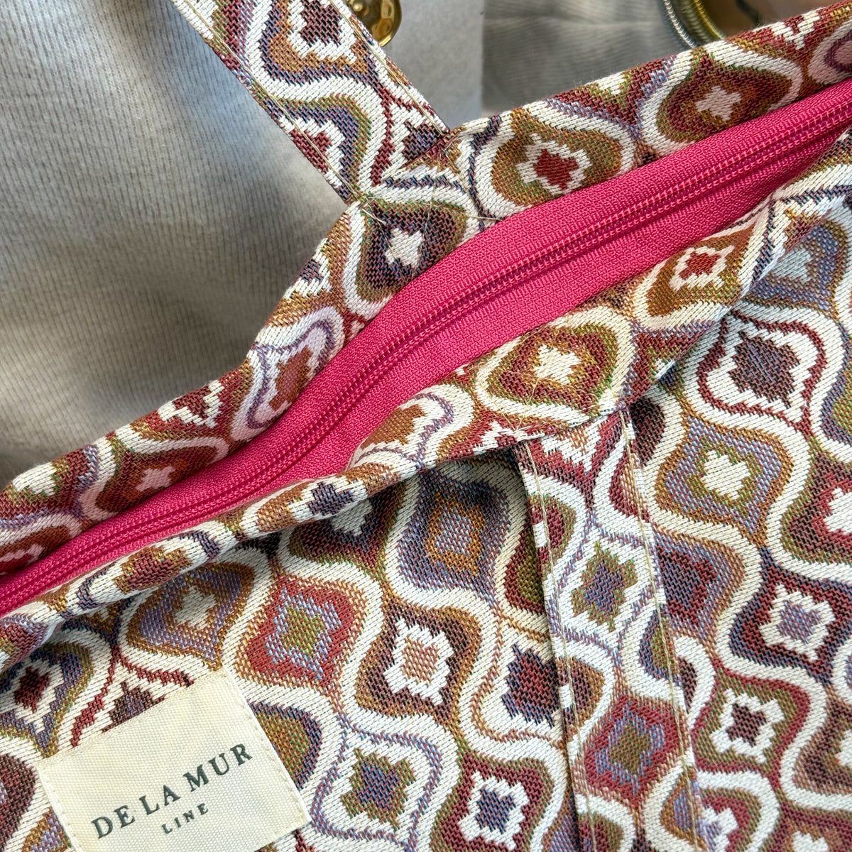 Detail of the open pink zip closure on the DE LA MUR Onda jacquard tote bag