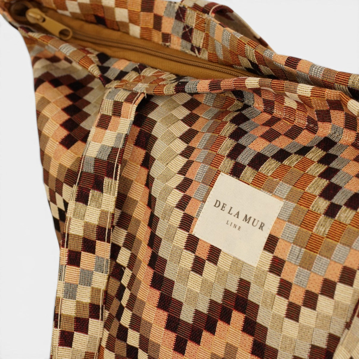 Open DE LA MUR Pier zigzag bag showing zipper closure and inner Line label