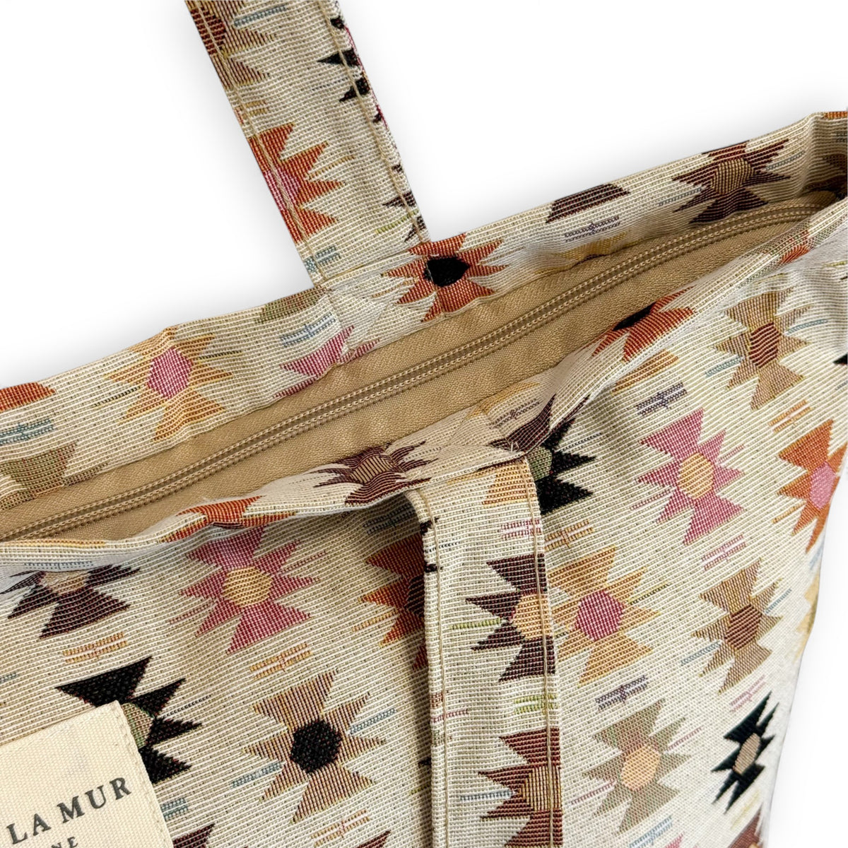 Close-up of the top zip and DE LA MUR Line label on the Royal jacquard tote