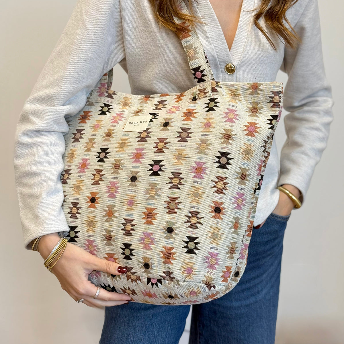 Model carrying the DE LA MUR Royal pink and orange jacquard tote on the shoulder