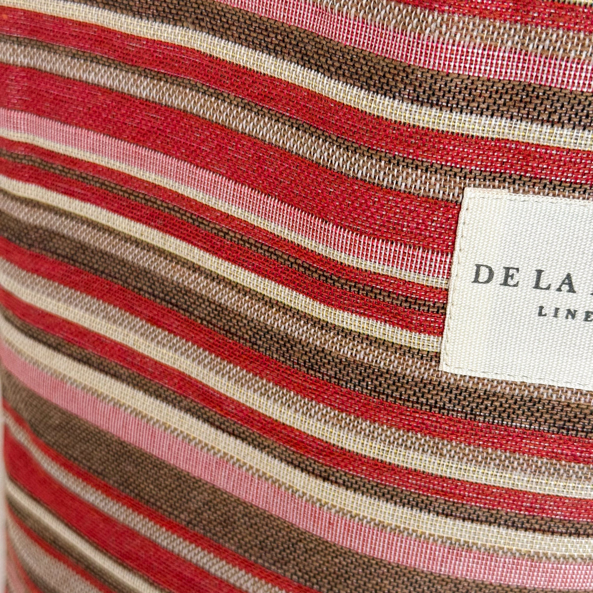 Close-up of pink and brown striped jacquard fabric and DE LA MUR label