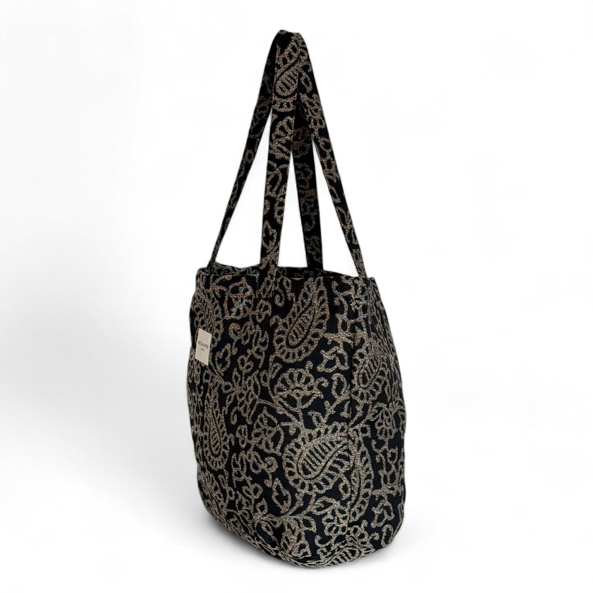 Side three-quarter view of the DE LA MUR Teide paisley jacquard tote bag with long handles