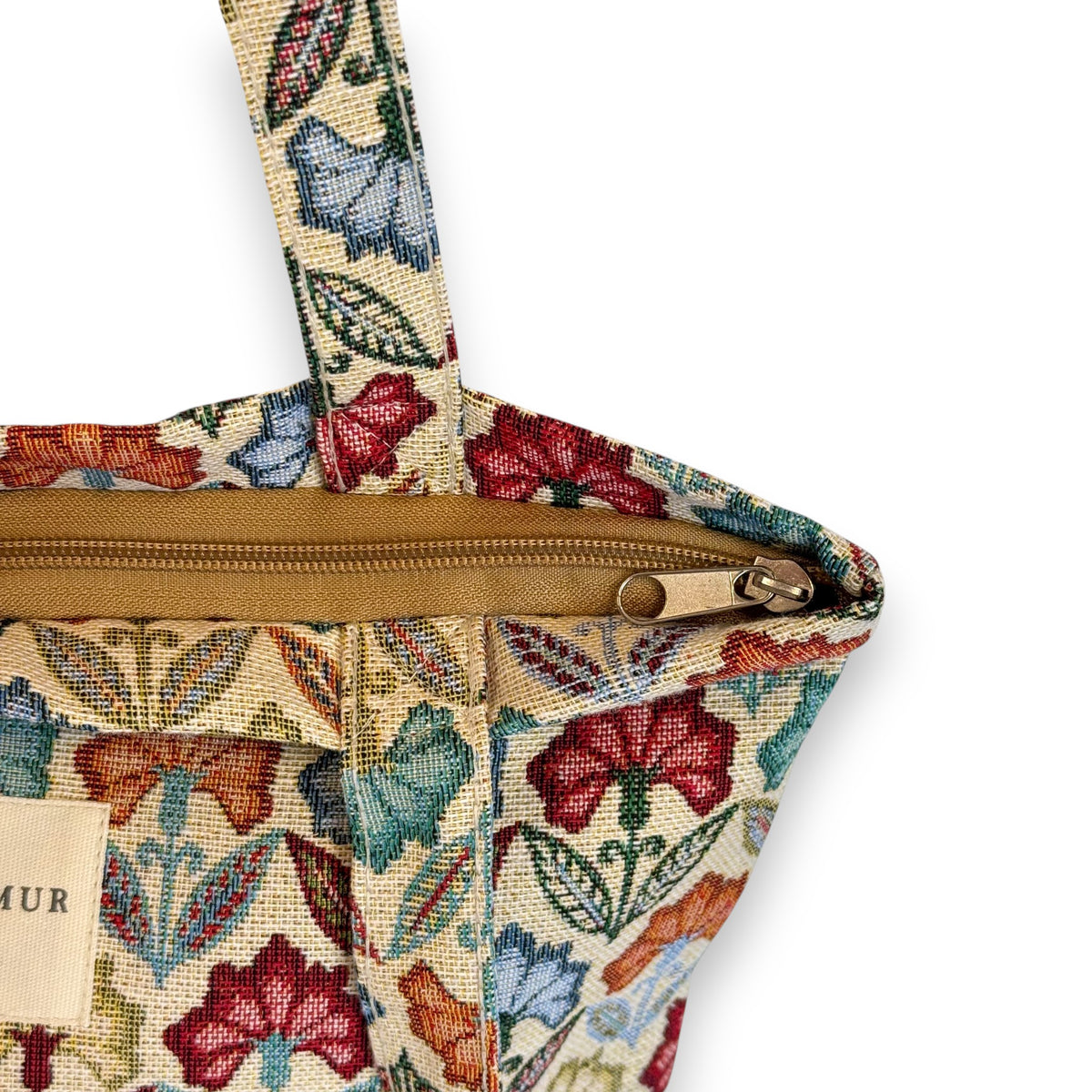 Model carrying the DE LA MUR Flora floral bag, with feature highlights