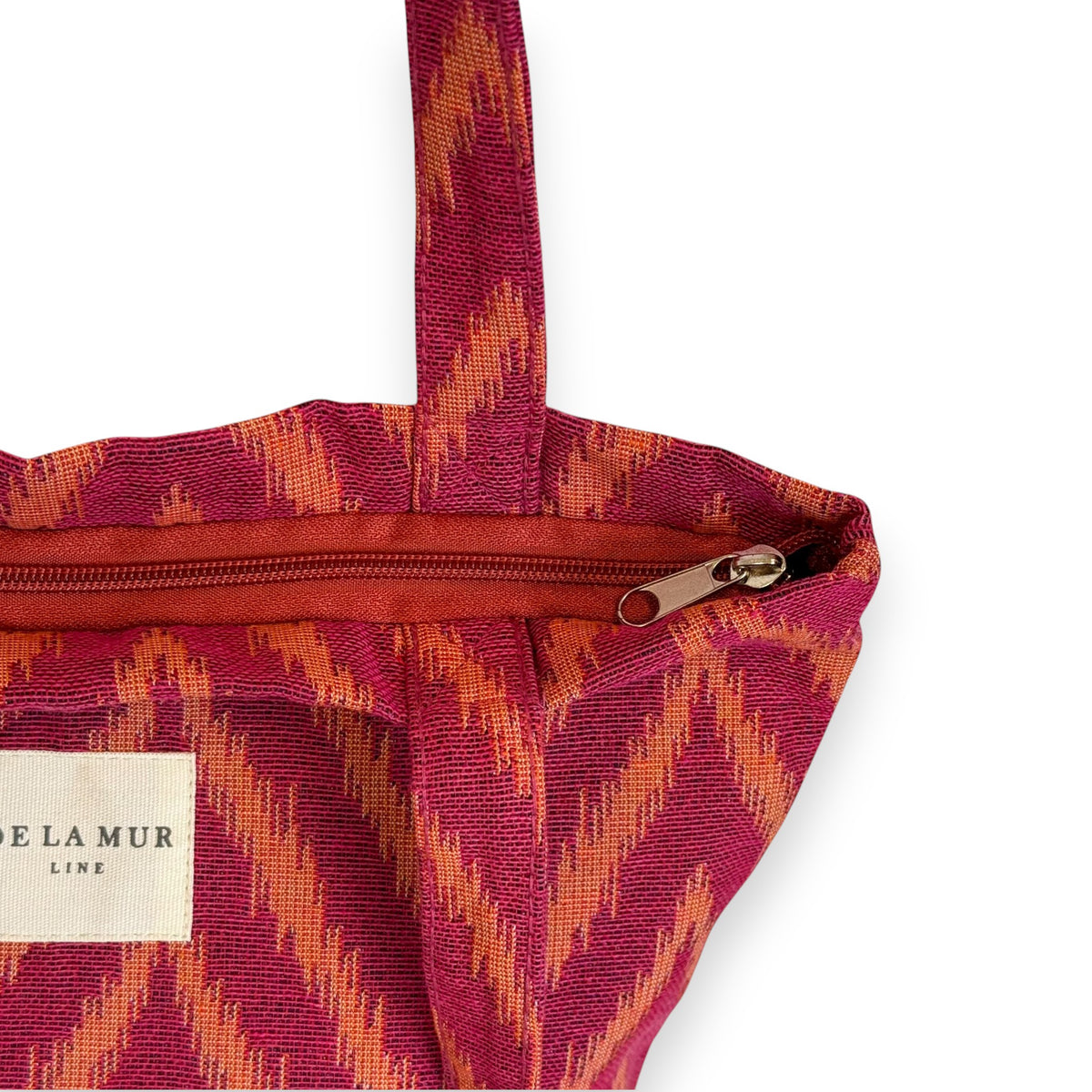 Open DE LA MUR Fuego bag showing the top zip closure and Line label