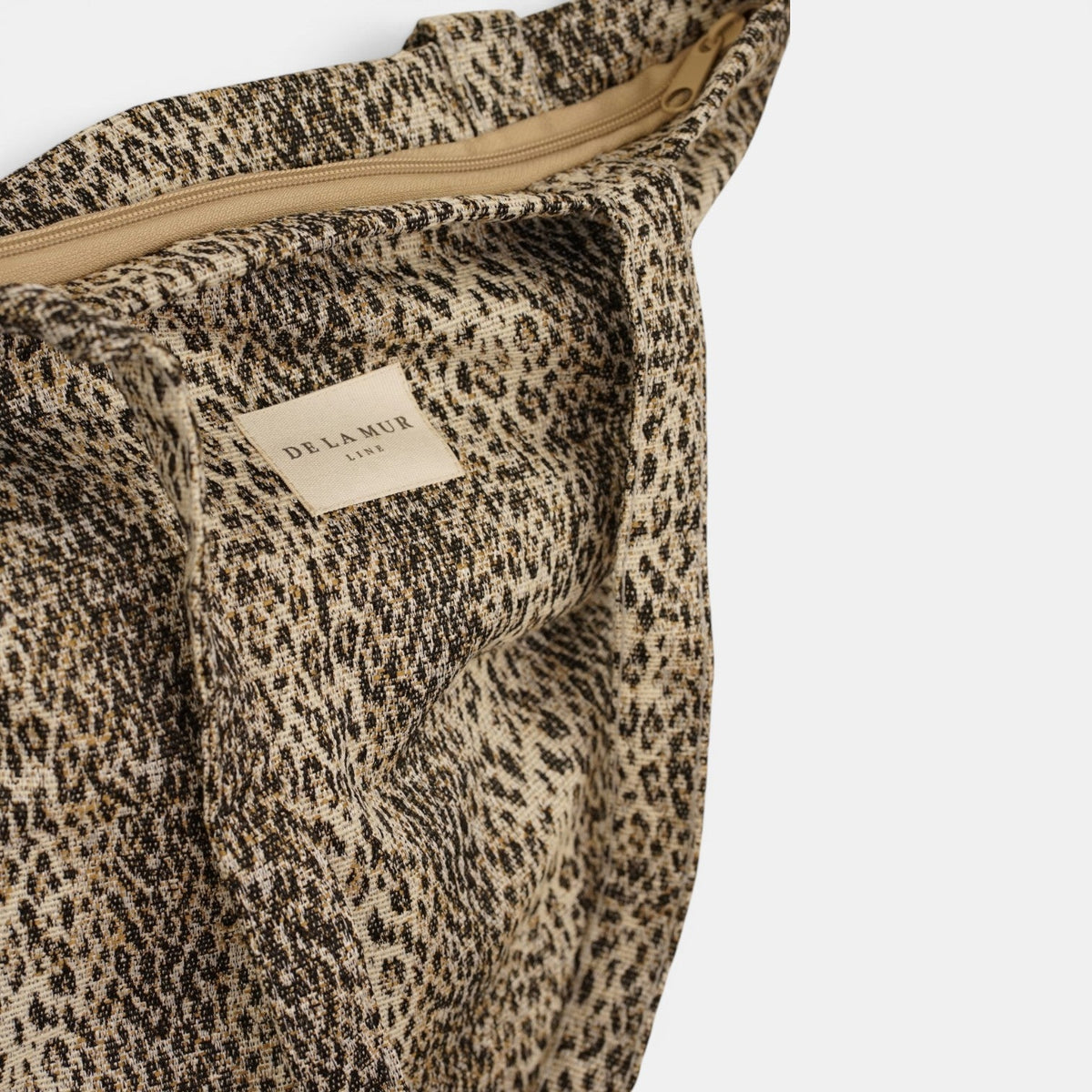 Open DE LA MUR Leo zippered bag showing the lined interior and top zip closure