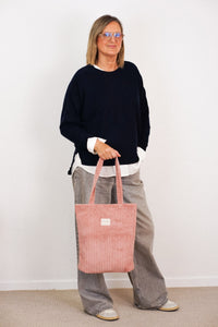 DE LA MUR Corduroy Medium Zippered Bag in dusty rose, carried by a model