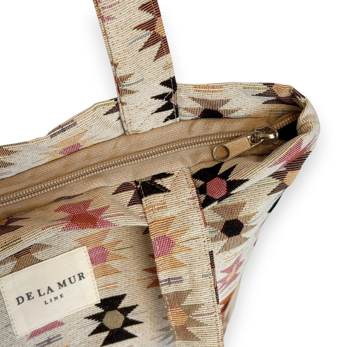 Open DE LA MUR Royal bag showing beige top zip closure and Aztec jacquard weave