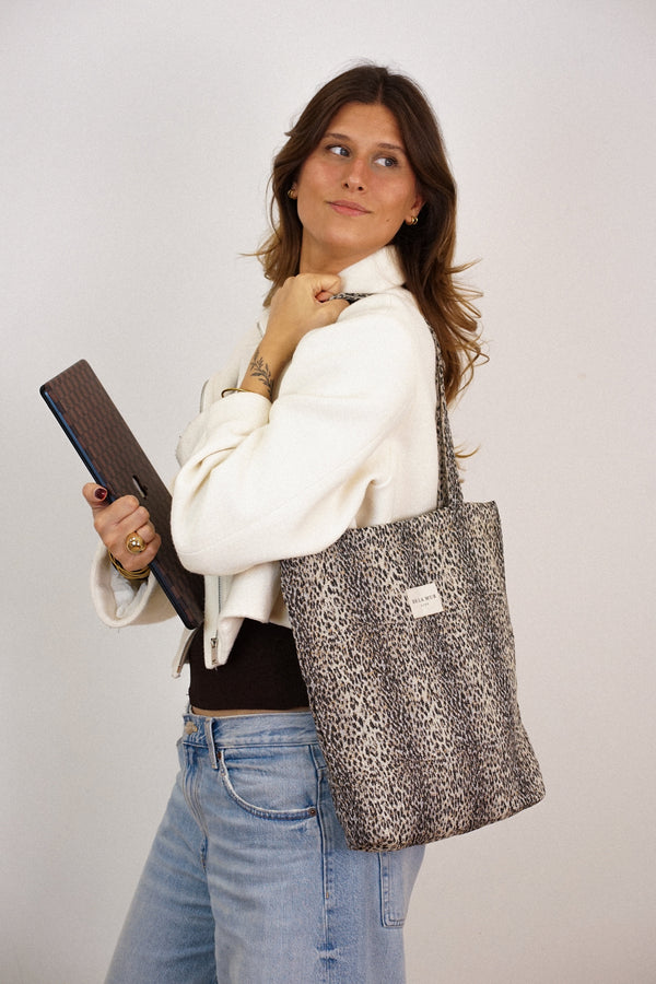 Model carrying DE LA MUR Leo leopard jacquard zippered bag on the shoulder, lifestyle shot