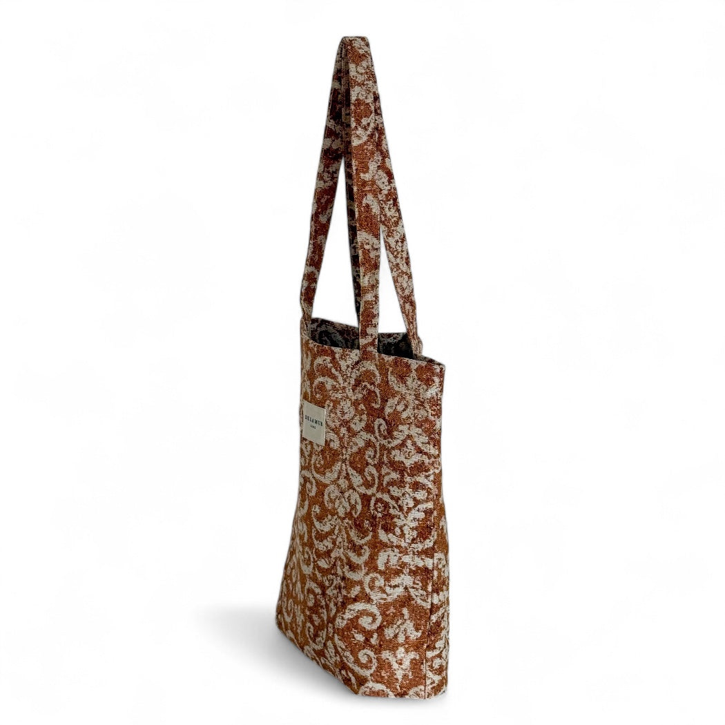 Side view of the DE LA MUR Mosti terracotta and cream jacquard tote bag