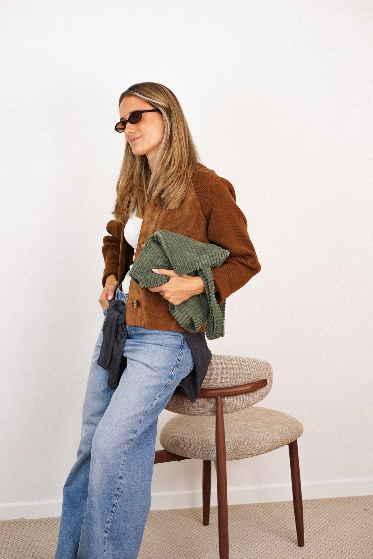 DE LA MUR Musgo olive green corduroy bag held by a seated model, lifestyle shot