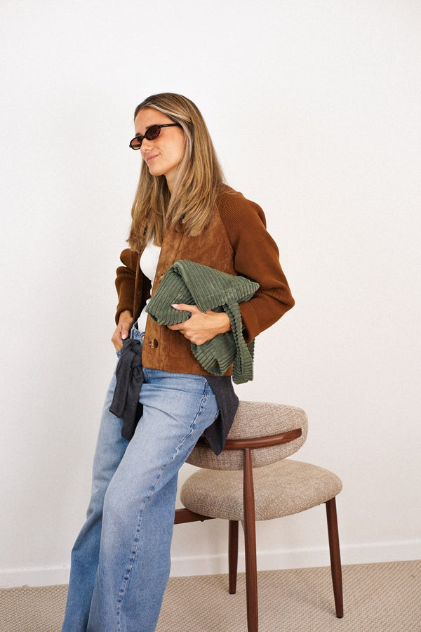 DE LA MUR Musgo olive green corduroy bag held by a seated model, lifestyle shot