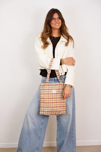 DE LA MUR Zia terracotta gingham jacquard bag worn on the shoulder by a model, lifestyle shot