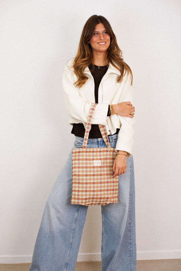 DE LA MUR Zia terracotta gingham jacquard bag worn on the shoulder by a model, lifestyle shot