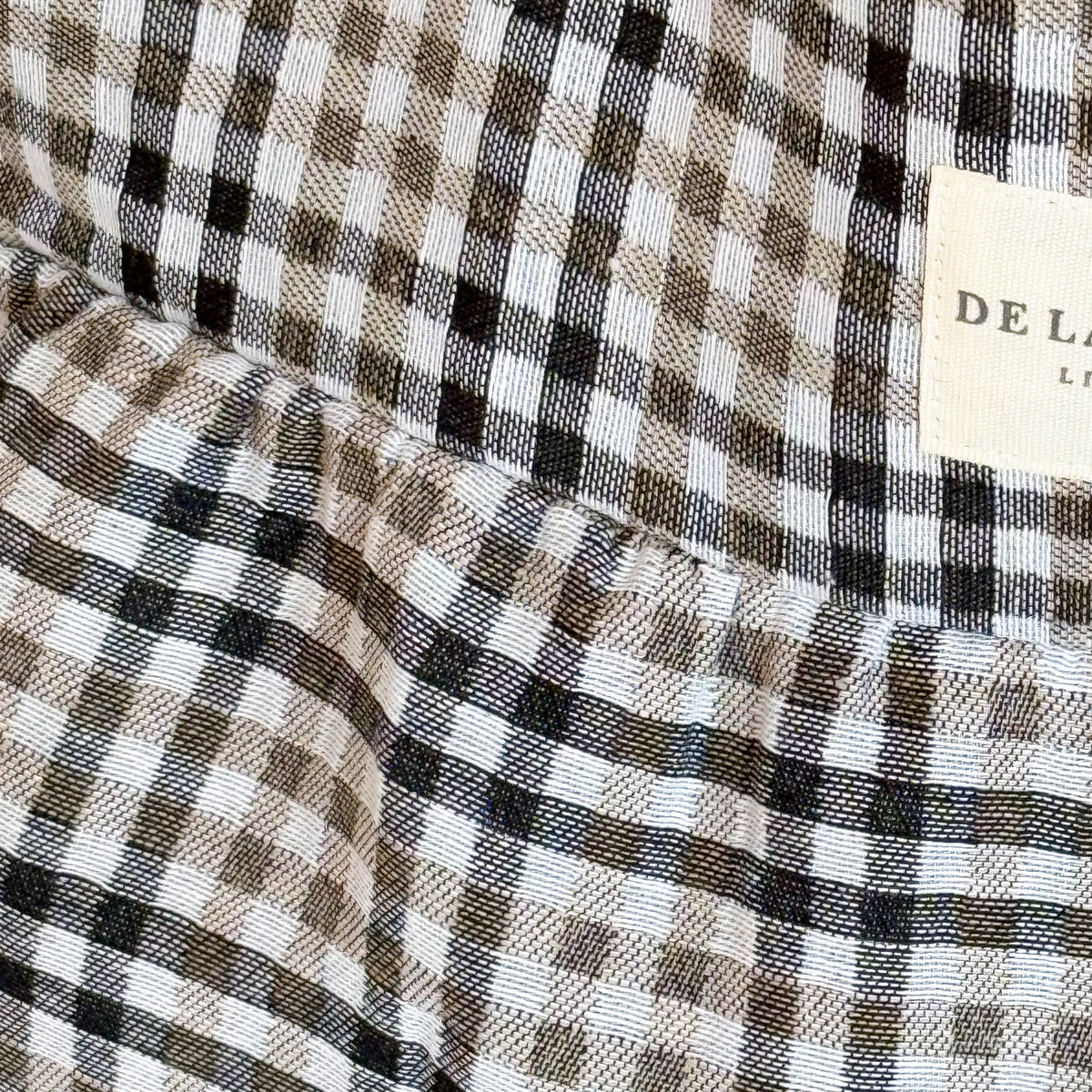 Close-up of the black and beige check fabric and DE LA MUR Line label on the Lian tote
