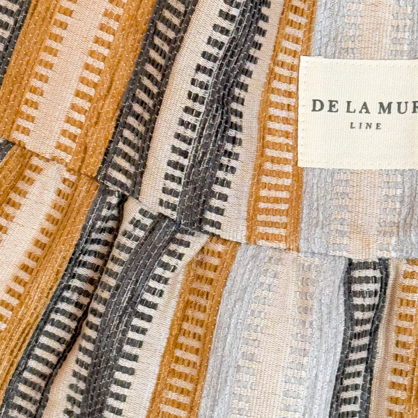 Close-up of the striped jacquard weave and DE LA MUR Line label on the Tron tote