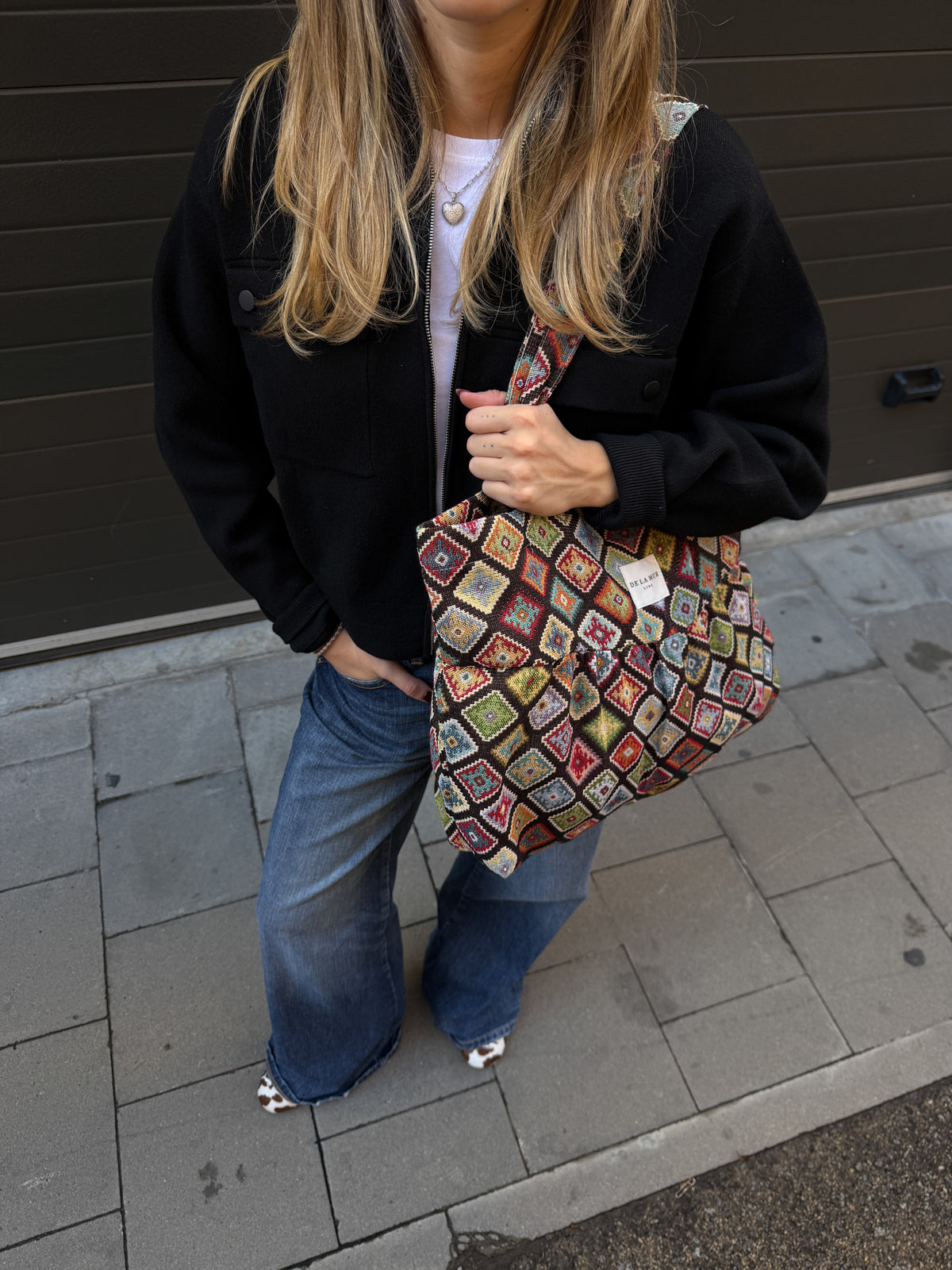Model carrying the DE LA MUR Join multicolor jacquard tote bag outdoors